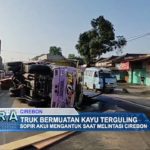 Truk Bermuatan Kayu Terguling