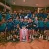 Pemain Arsenal merayakan kemenangan dengan mengangkat trofi Premier League di tengah lapangan, suporter bersor