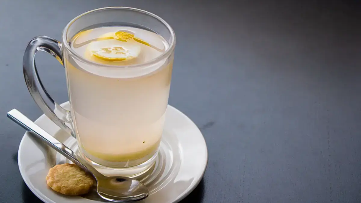 Fakta atau Mitos! Minum Air Hangat dengan Lemon Setiap Pagi, Benarkah Bisa Turunkan Berat Badan? Segelas air hangat dengan perasan lemon di atas meja