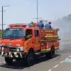 Petugas pemadam kebakaran (Damkar) menyemprotkan air ke jalan untuk membersihkan abu vulkanik erupsi Gunung An