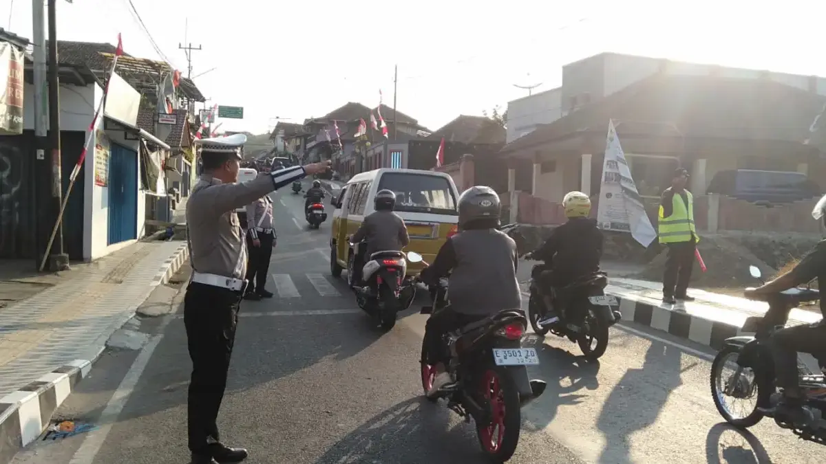 Personel Polres Kuningan saat mengatur lalu lintas di titik rawan pada pagi hari.
